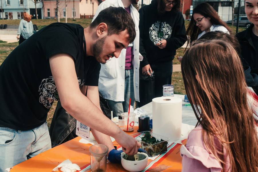 Exhibitor preparing a hands-on experiment for a young visitor