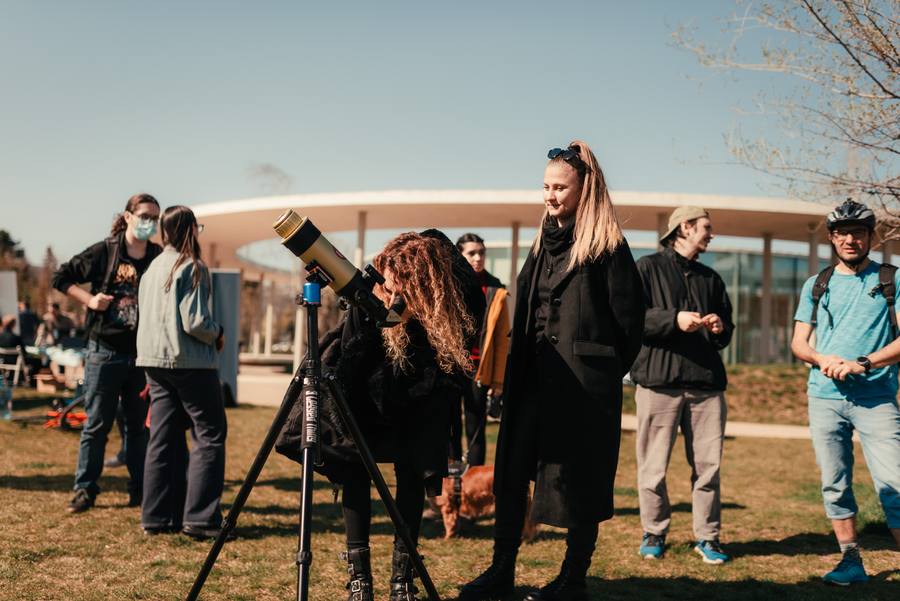 Visitors at a telescope in front of Pavilionul Tinerilor