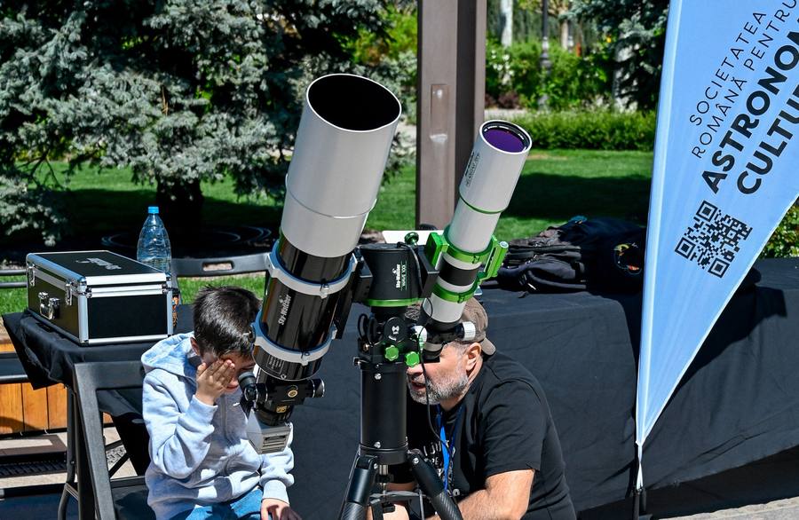 Child looking through a telescope at the cultural astronomy stand