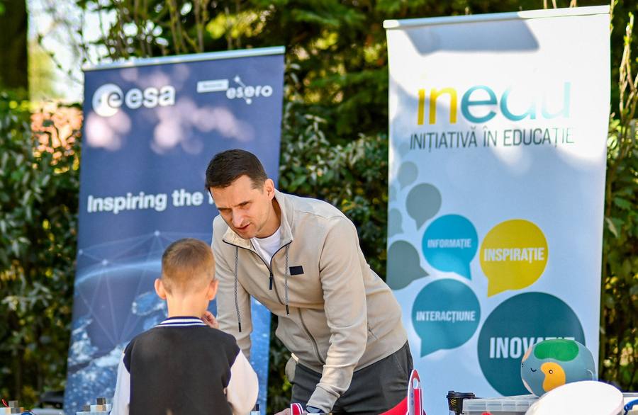 Young visitor at the INEDU stand, next to an ESA banner
